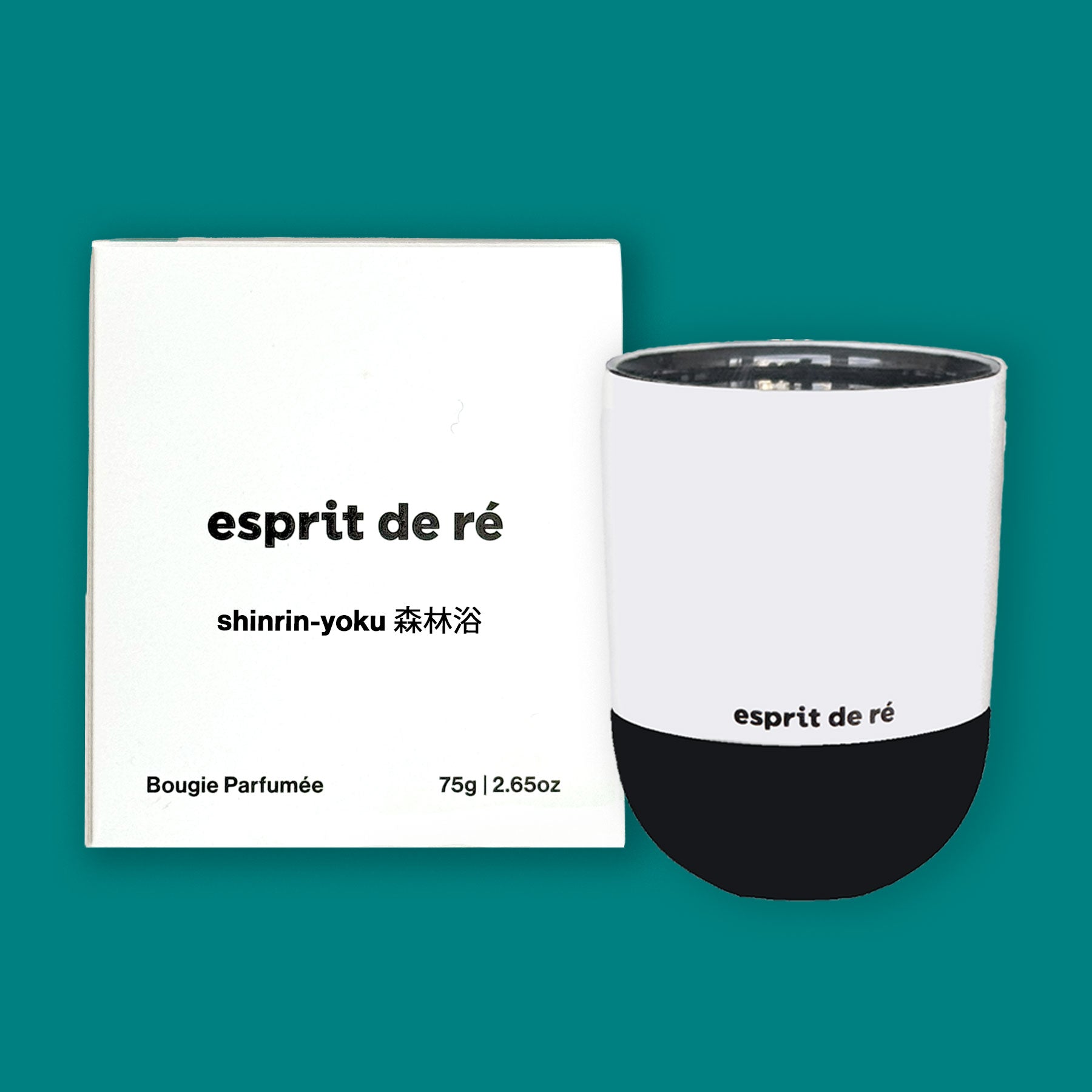 Bougie blanche et noire de 75 g avec emballage étiqueté "esprit de re", avec le nom de la bougie - shinrin-yoku sur un fond vert forêt profond. La boîte a bougie parfumée dans le coin gauche en face de la taille de la bougie 75g | 2,5 oz.
